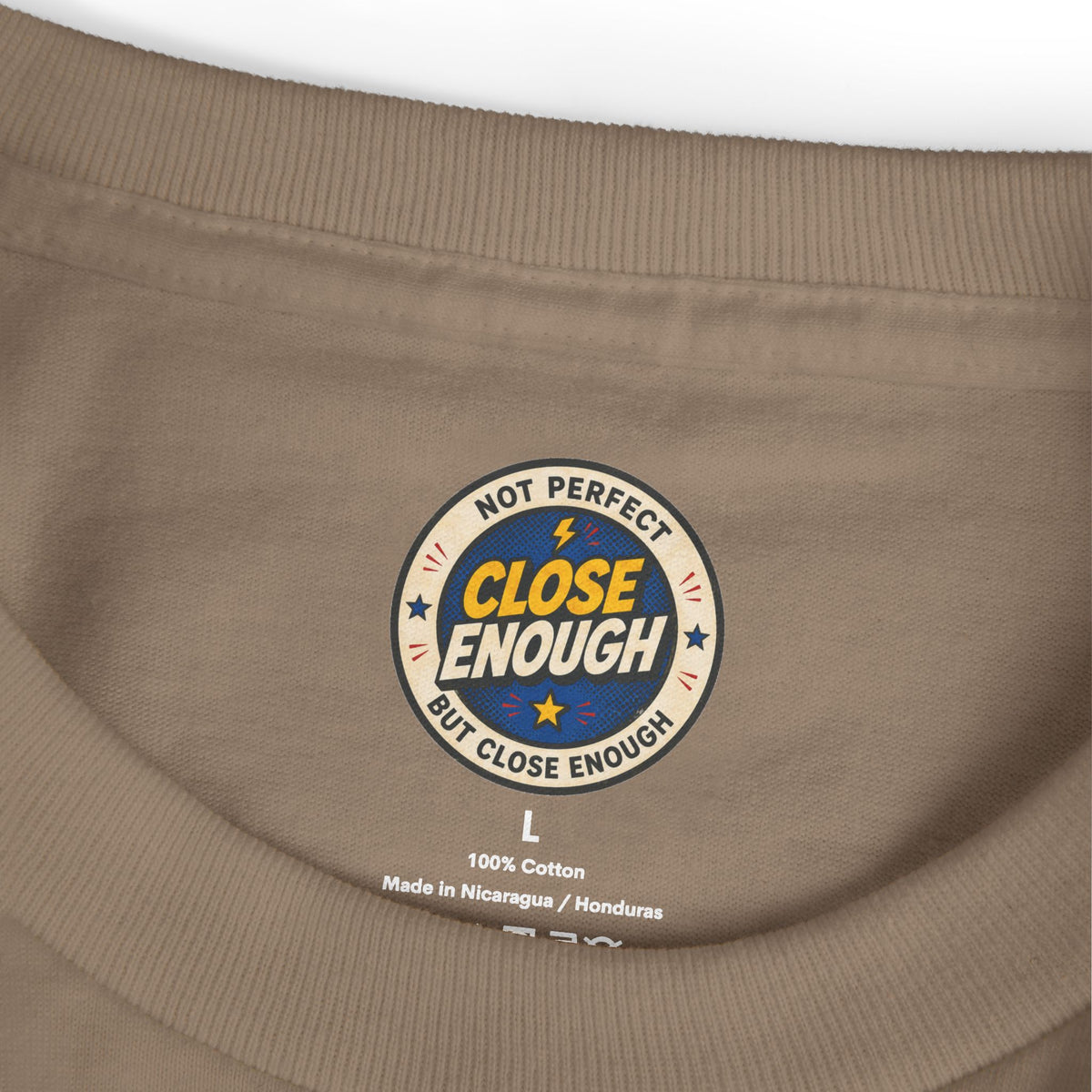 Close Enough printed neck label on faded brown garment-dyed tee