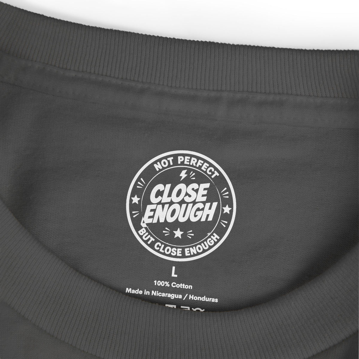 Close Enough printed neck label on Faded Black garment-dyed tee
