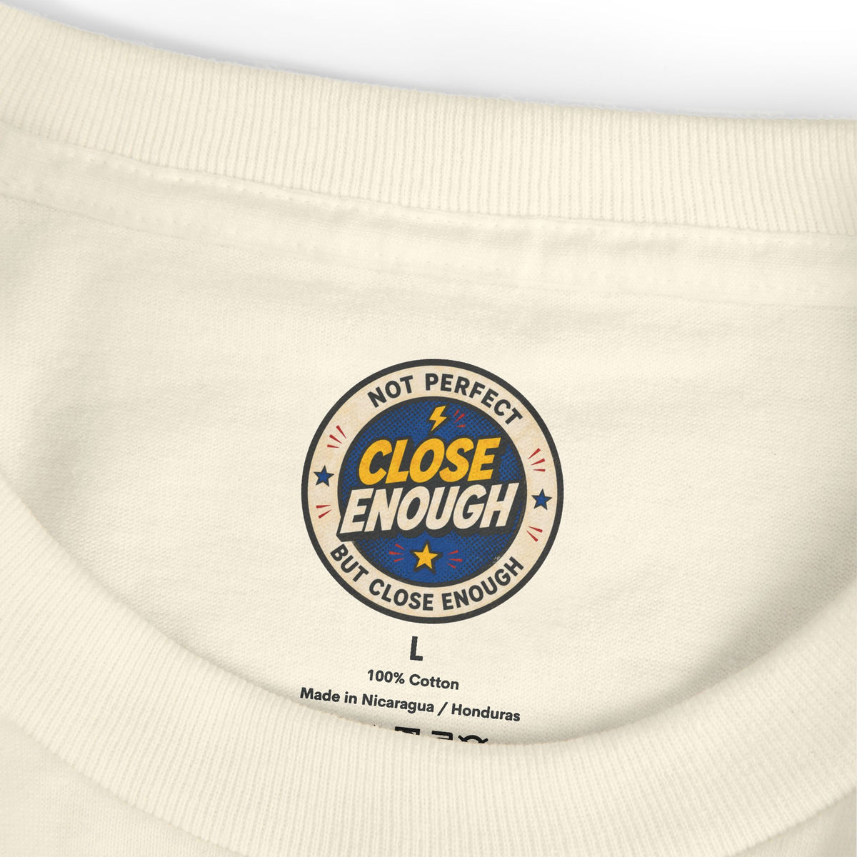 CLOSE ENOUGH neck label on the ON MUTE tee in Faded Cream
