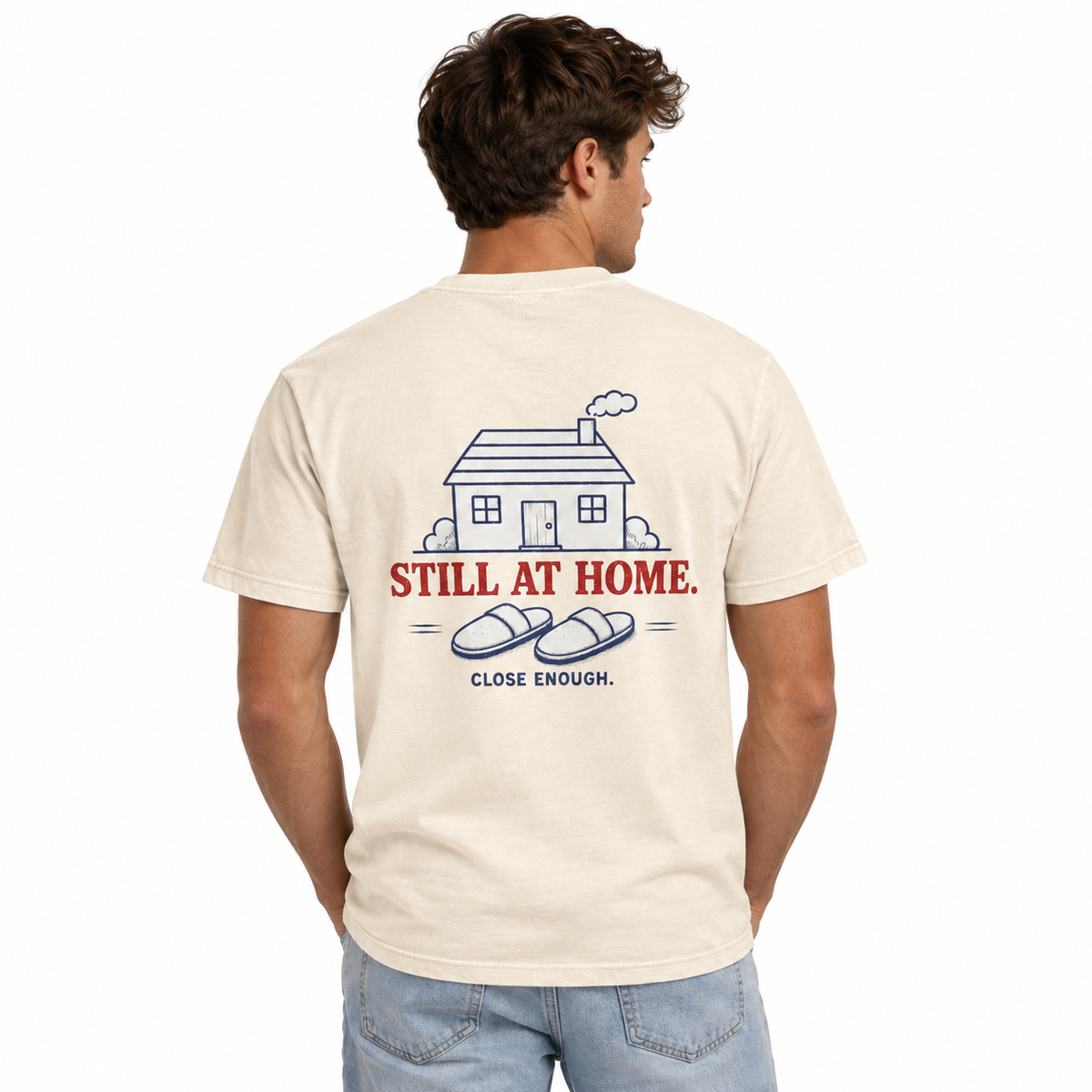 Man wearing the Be Right There cream tee showing Still At Home back artwork