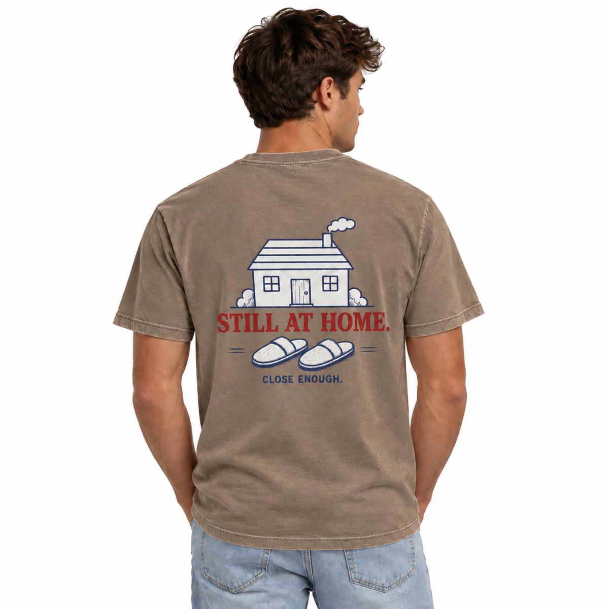 Man wearing the Be Right There faded brown tee showing Still At Home back artwork