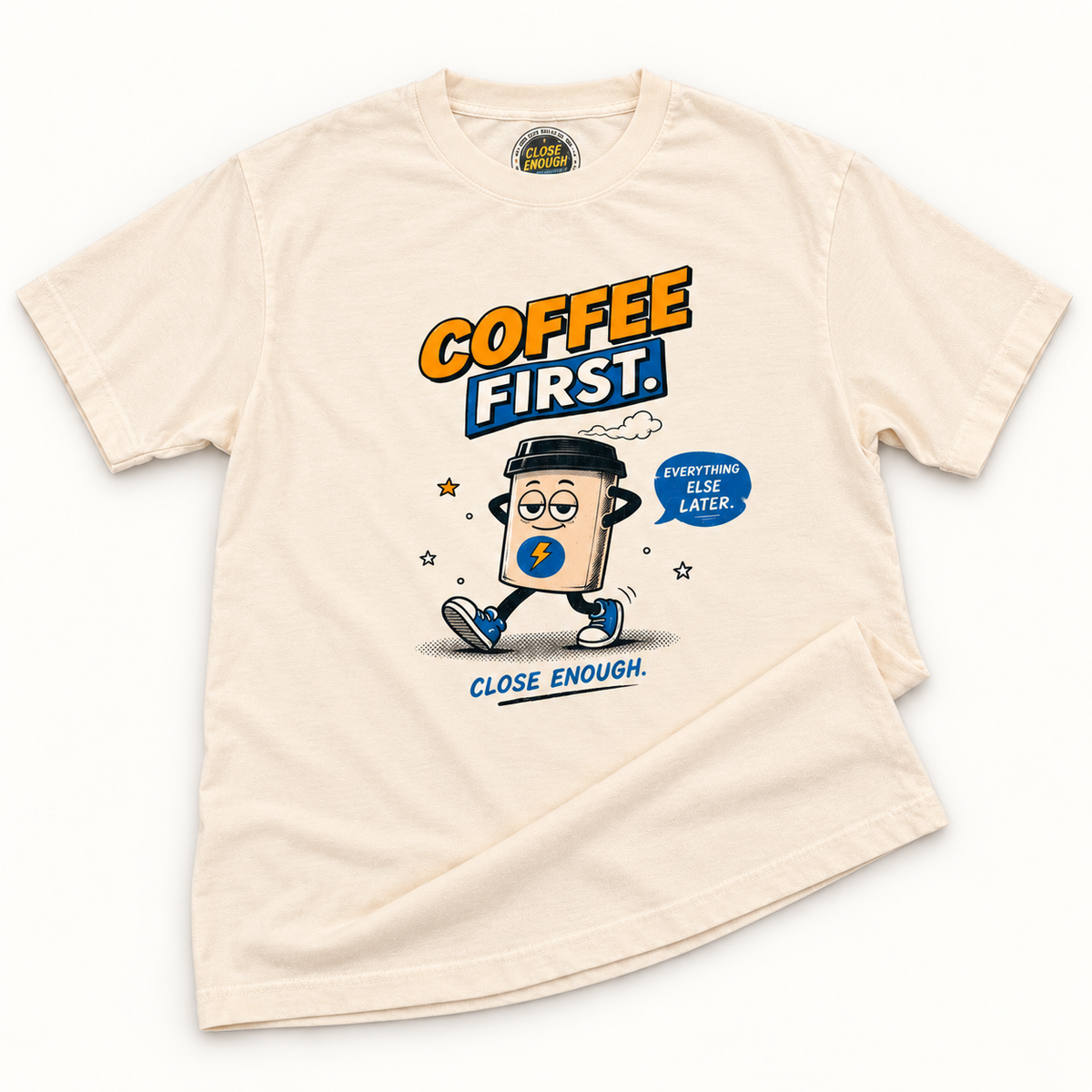 Coffee First Tee real product sample in faded cream showing the printed graphic and garment-dyed fabric